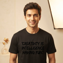 Rahul Kapoor wearing a black brush-style inspirational quote T-shirt in a professional portrait.